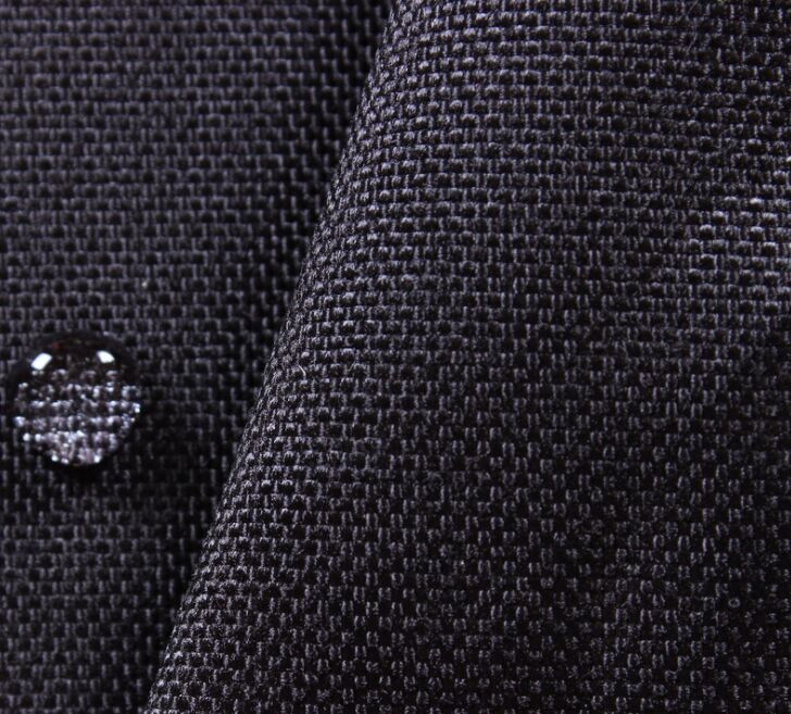 Close-up of black Cordura fabric with a water droplet sitting on the surface