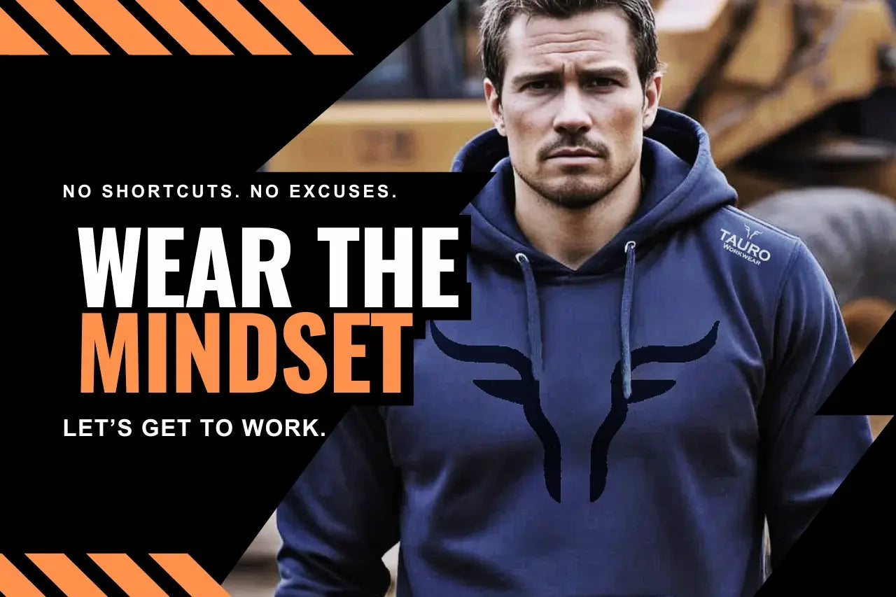 Man wearing a blue hoodie with Tauro Workwear logo, standing in front of a construction vehicle with motivational text.